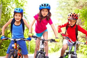 Children wearing helmet for safety in riding bicycle.