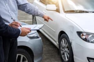 Car insurance agent checking for car damages.