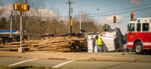 Logging truck overturn near intersection.