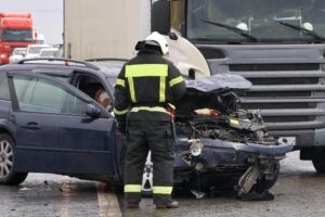 Featured image Police officer checking damages of truck vs car.