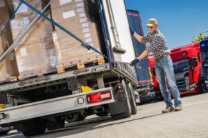 Featured image Truck driver loading cargo boxes into a commercial truck.