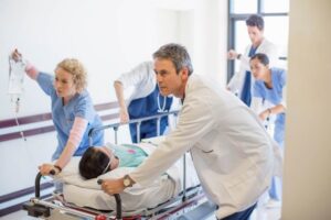 Doctors and nurses rushing patient to emergency room.